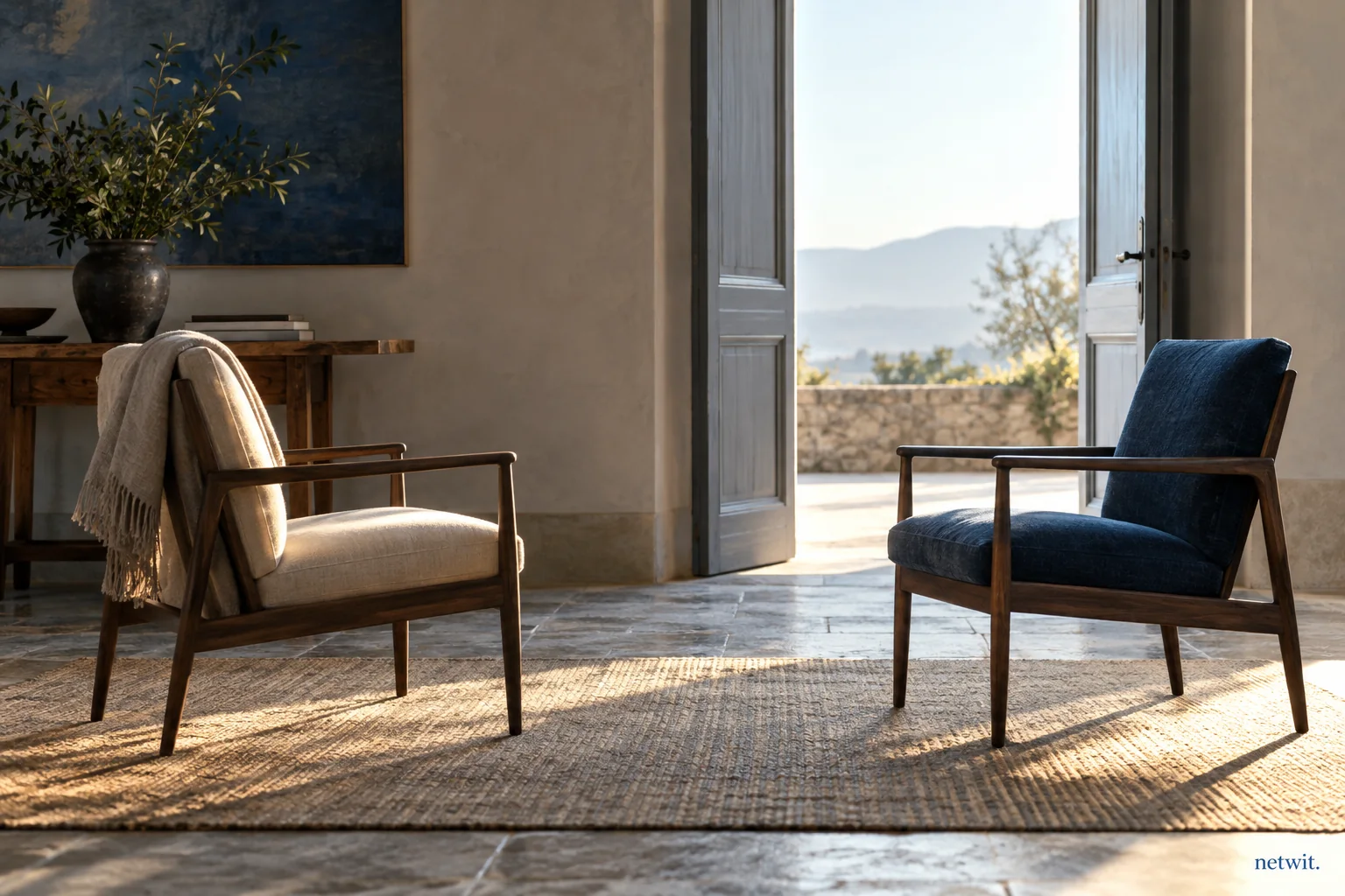 Two empty chairs facing each other with a small space between, simple room with an open doorway and soft morning light, reflective atmosphere.