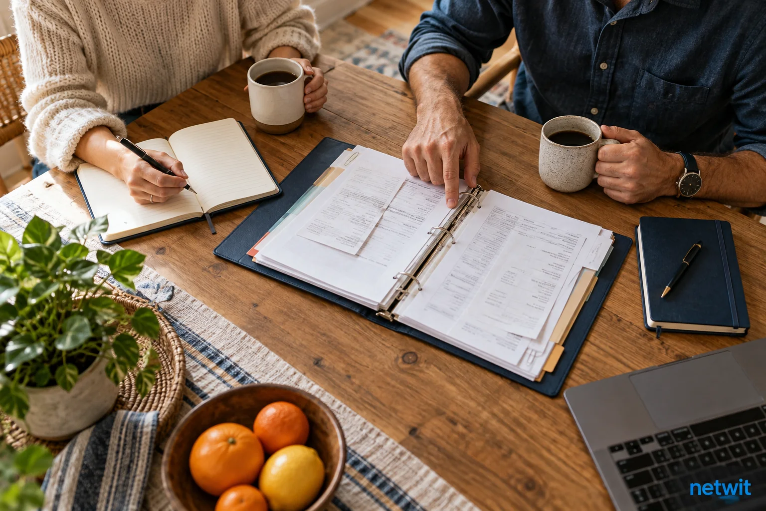 Overhead realistic kitchen table with two distinct personal notebooks and a shared household budget folder in center, two cups and two adults' hands planning together, no readable text..